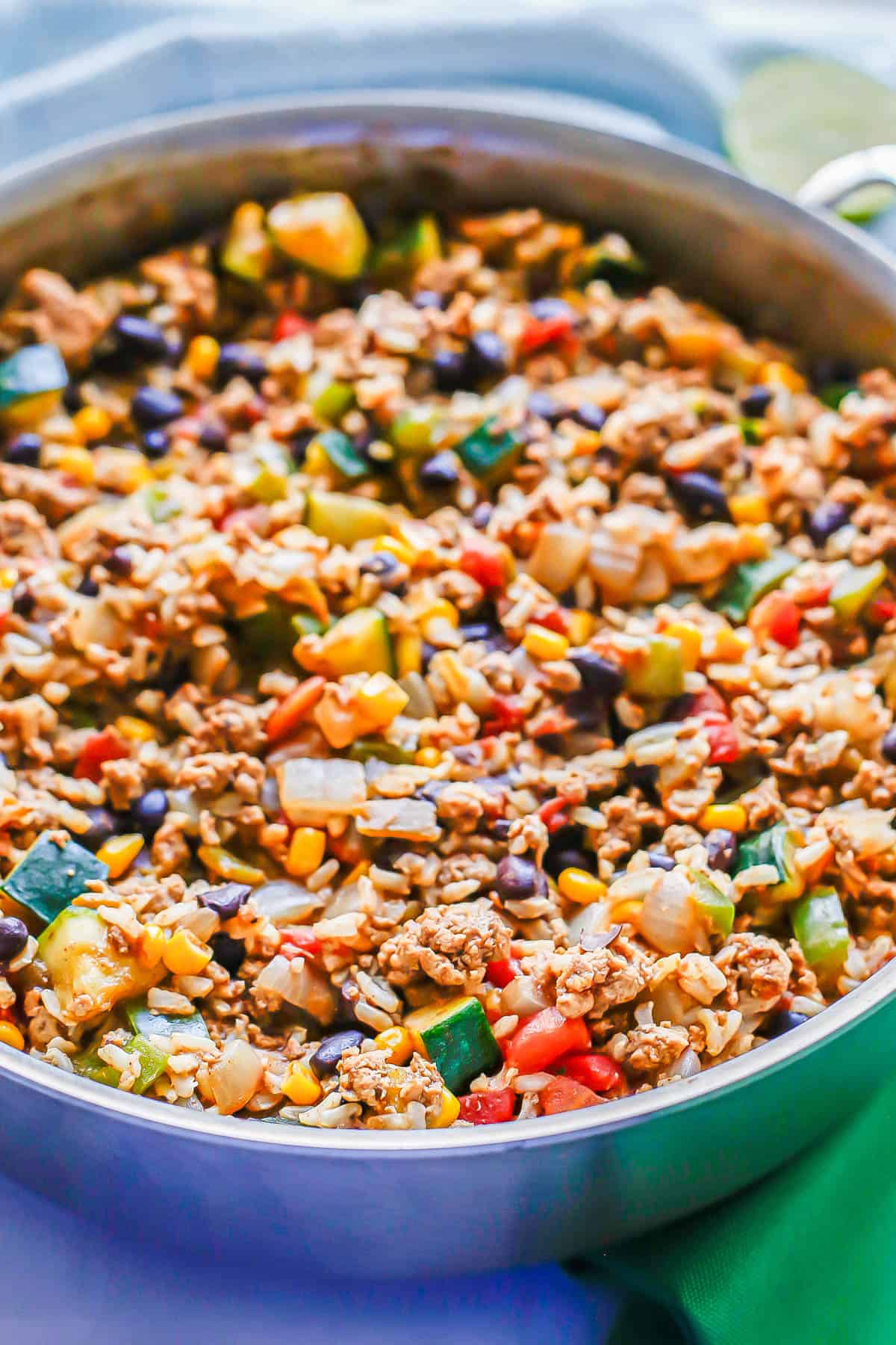 A mixture of turkey, beans, rice, zucchini and peppers in a large deep skillet.