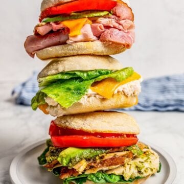 Zoom in of hot sandwich melts stacked on top of one another on a plate.