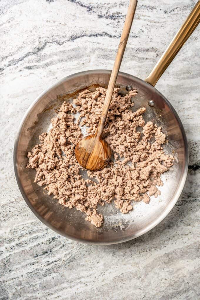 Cooked, crumbled ground turkey in a skillet.