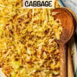 Close up of a platter of cooked, browned shredded cabbage with wooden serving spoons resting on the side and a text overlay on the photo.