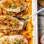 A spoon scooping up a baked chicken breast stuffed with stuffing from a casserole dish with a text overlay on the photo.