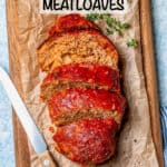 A sliced mini turkey meatloaf on a small wooden cutting board with sprigs of thyme nearby with a text overlay on the photo.