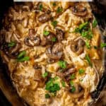 Slow cooker chicken marsala with mushrooms in a dark crock pot insert with a text overlay on the photo.