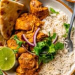 A fork resting in a bowl of rice and chicken tikka masala with naan bread to the side and a lime wedge for garnish and a text box over the photograph.