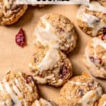 Cranberry oatmeal cookies scattered on a piece of parchment paper and a text overlay on the photo.