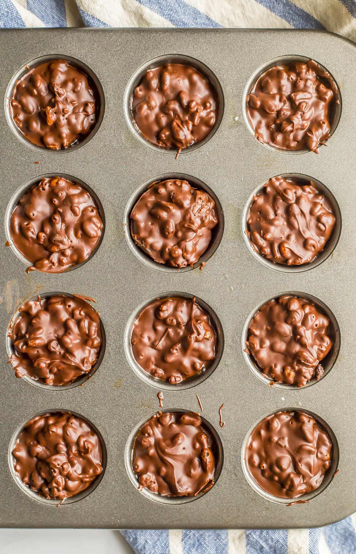 Homemade crunch cups in a mini muffin tin after being set up.
