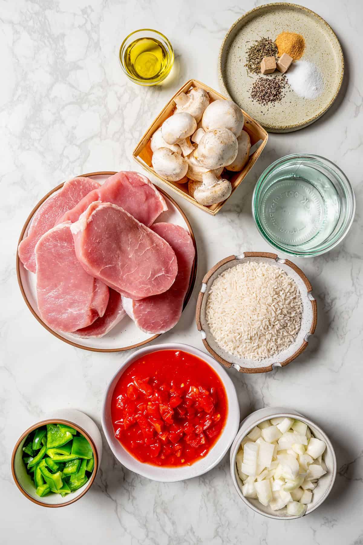 Ingredients laid out in separate dishes for making a pork chop and rice casserole.
