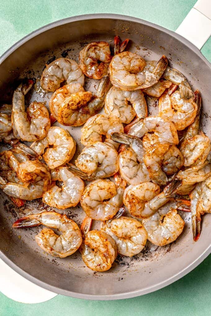Seasoned shrimp being cooked in a skillet.
