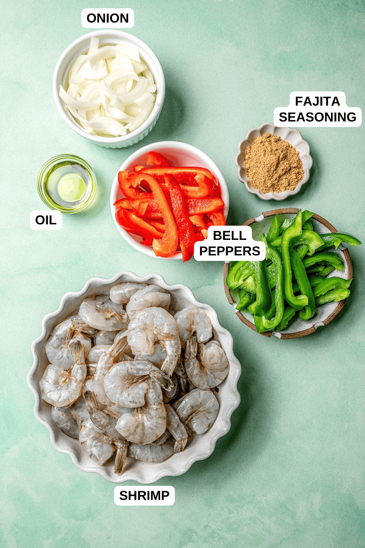 Ingredients laid out in separate bowls, including shrimp, bell peppers, onion, fajita seasoning and oil.
