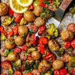 A spatula scooping up some roasted veggies and sausage from a sheet pan dinner with a text overlay on the photo.