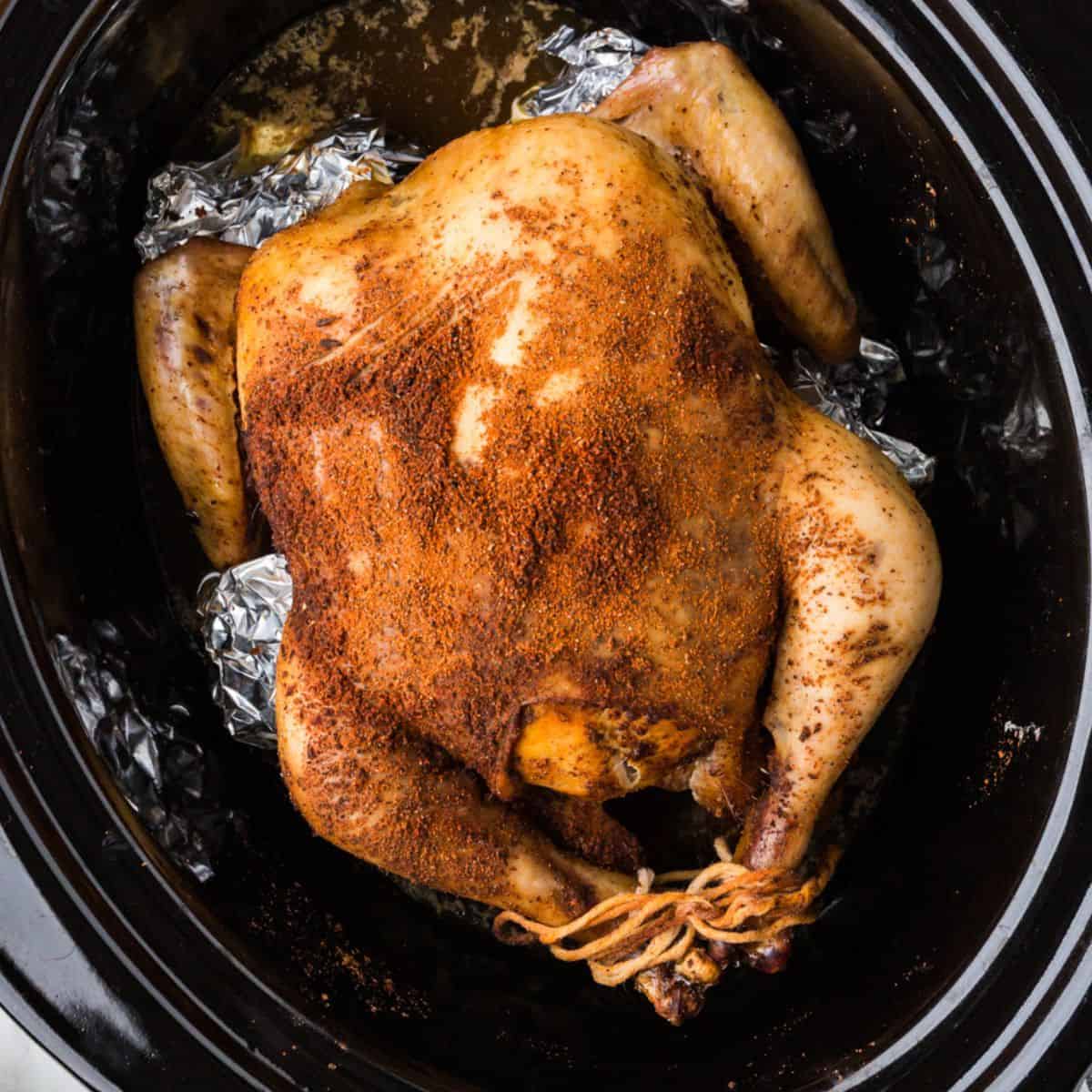 A whole roast chicken in a crock pot insert.