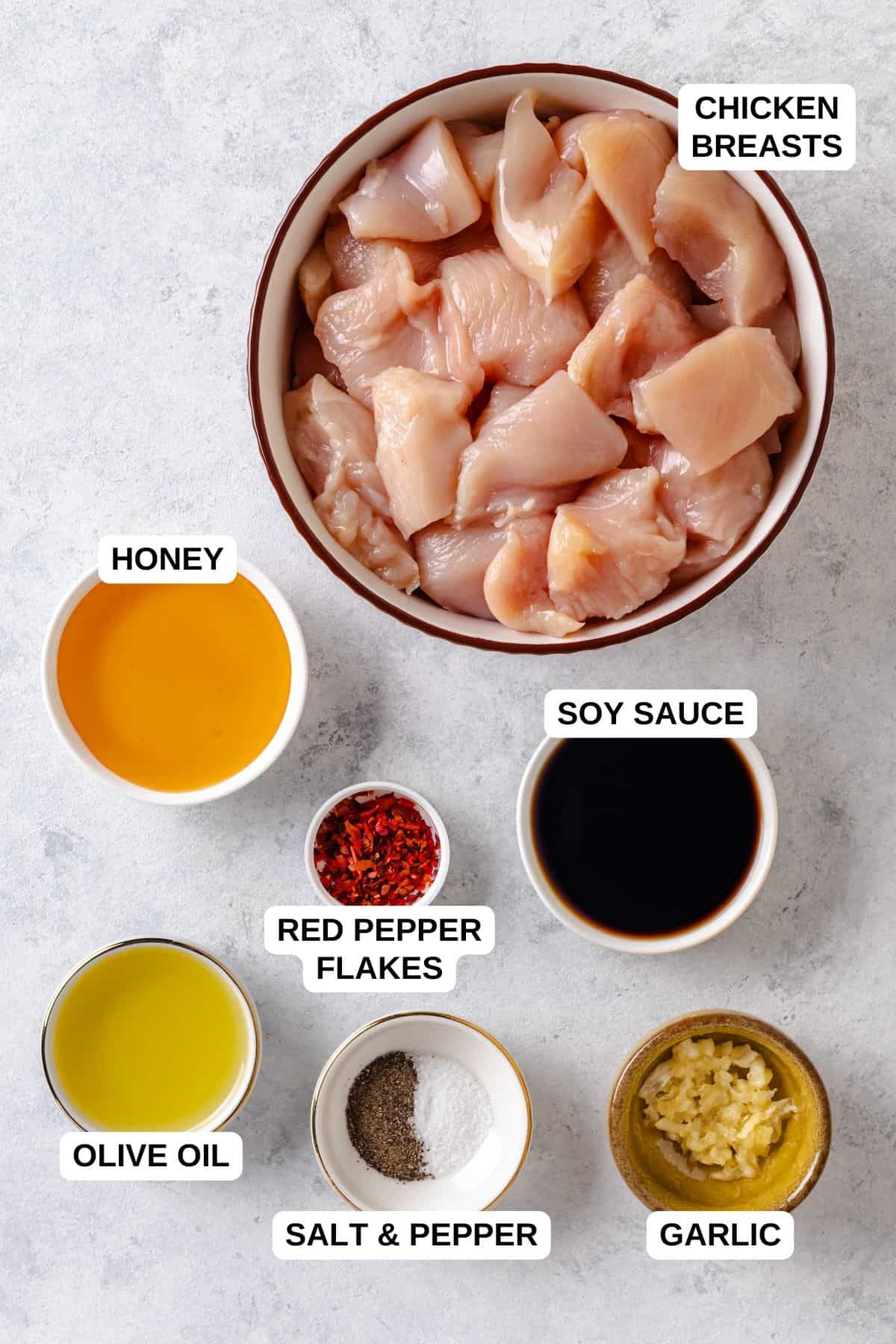 Ingredients laid out in separate bowls for making a honey garlic chicken recipe.