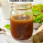 A glass jar with a homemade soy ginger vinaigrette with sliced ginger pieces to the side and a text overlay on the photo.