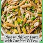 Close up of a small wooden serving spoon resting in a white skillet full of a cheesy healthy chicken pasta with zucchini and peas with a border and text around the photo.
