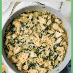 A cheesy chicken and brown rice skillet with spinach wilted in and a border and text around the photo.