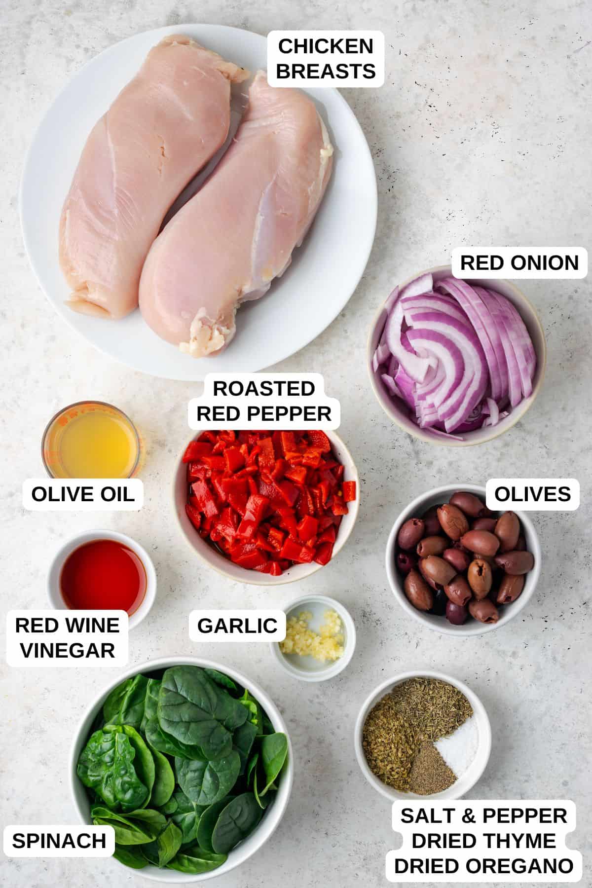 Ingredients laid out in separate containers for making a chicken recipe with red onion, spinach and roasted red peppers.