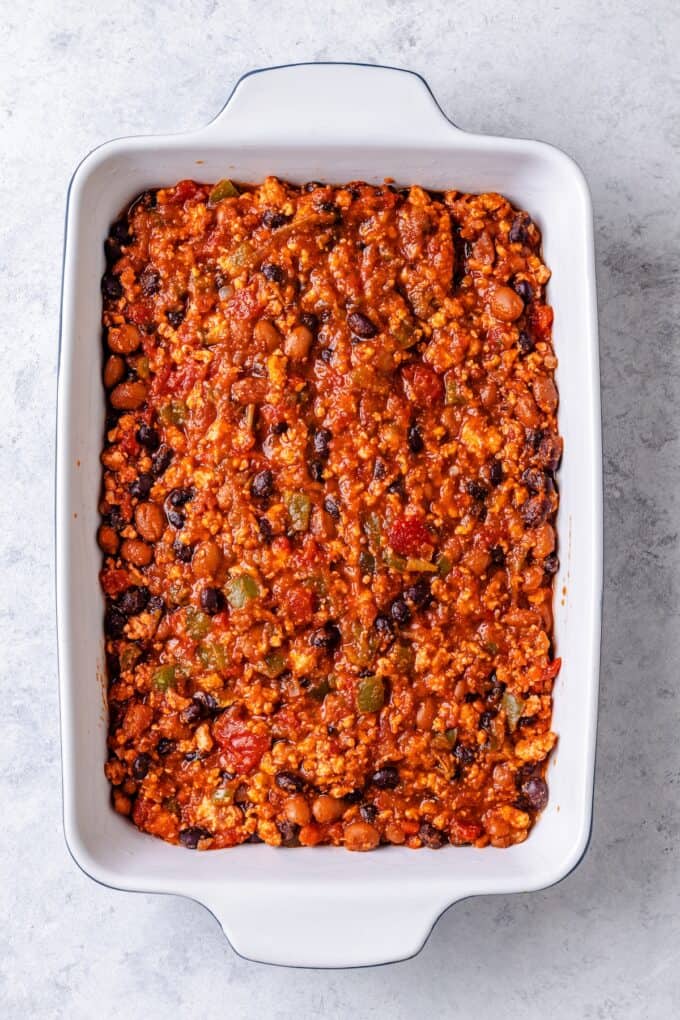 A hearty turkey and bean chili spread into a large white casserole dish.