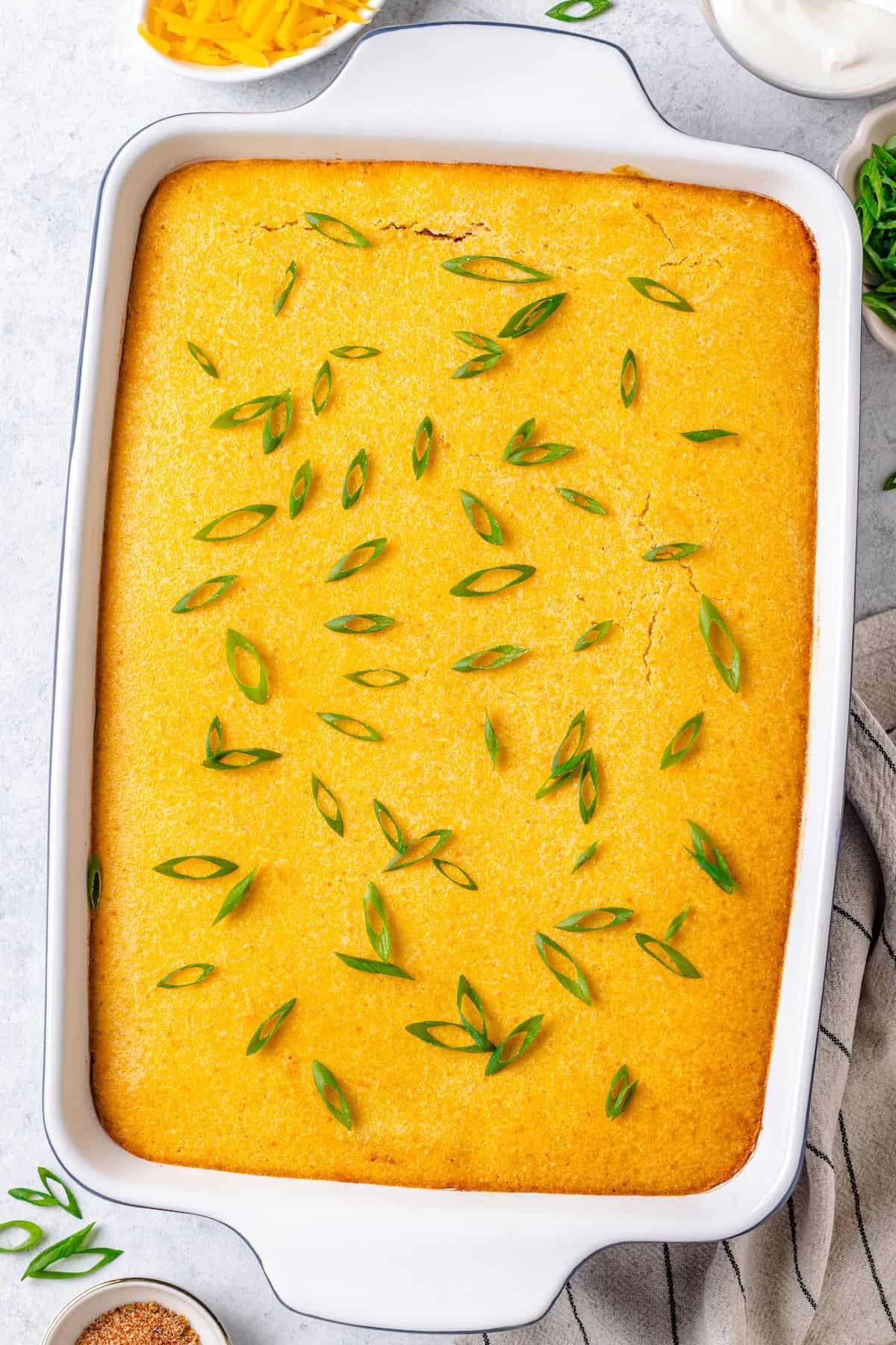 Baked chili cornbread casserole with sliced green onions on top.