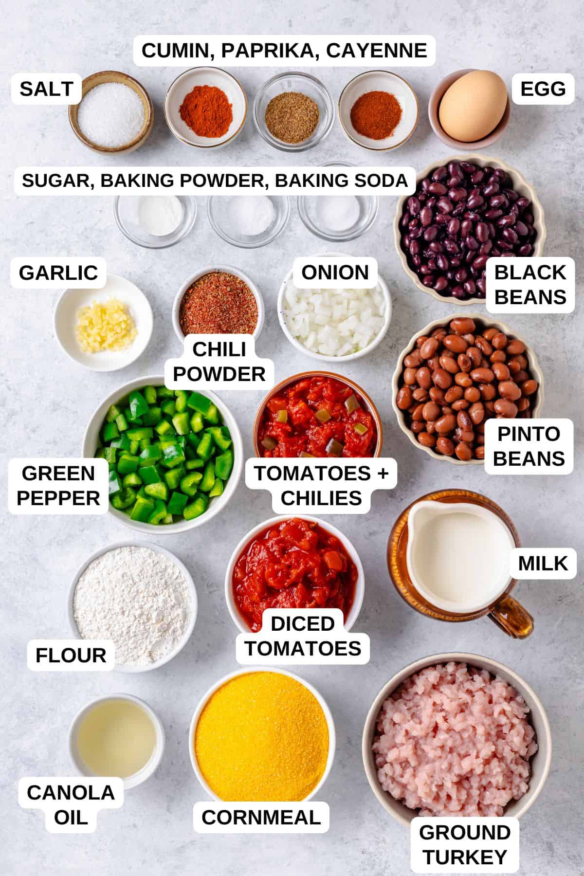 Ingredients laid out in separate bowls for making a chili and cornbread recipe with beans, peppers and tomatoes.