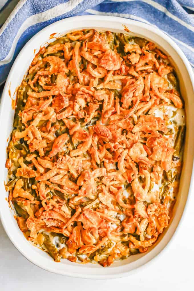 A green bean casserole in a white dish with French fried onions on top.