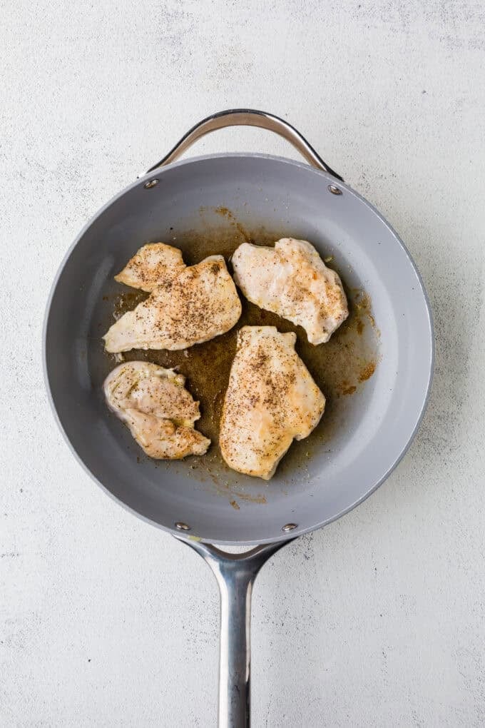 Seared chicken breasts in a skillet.