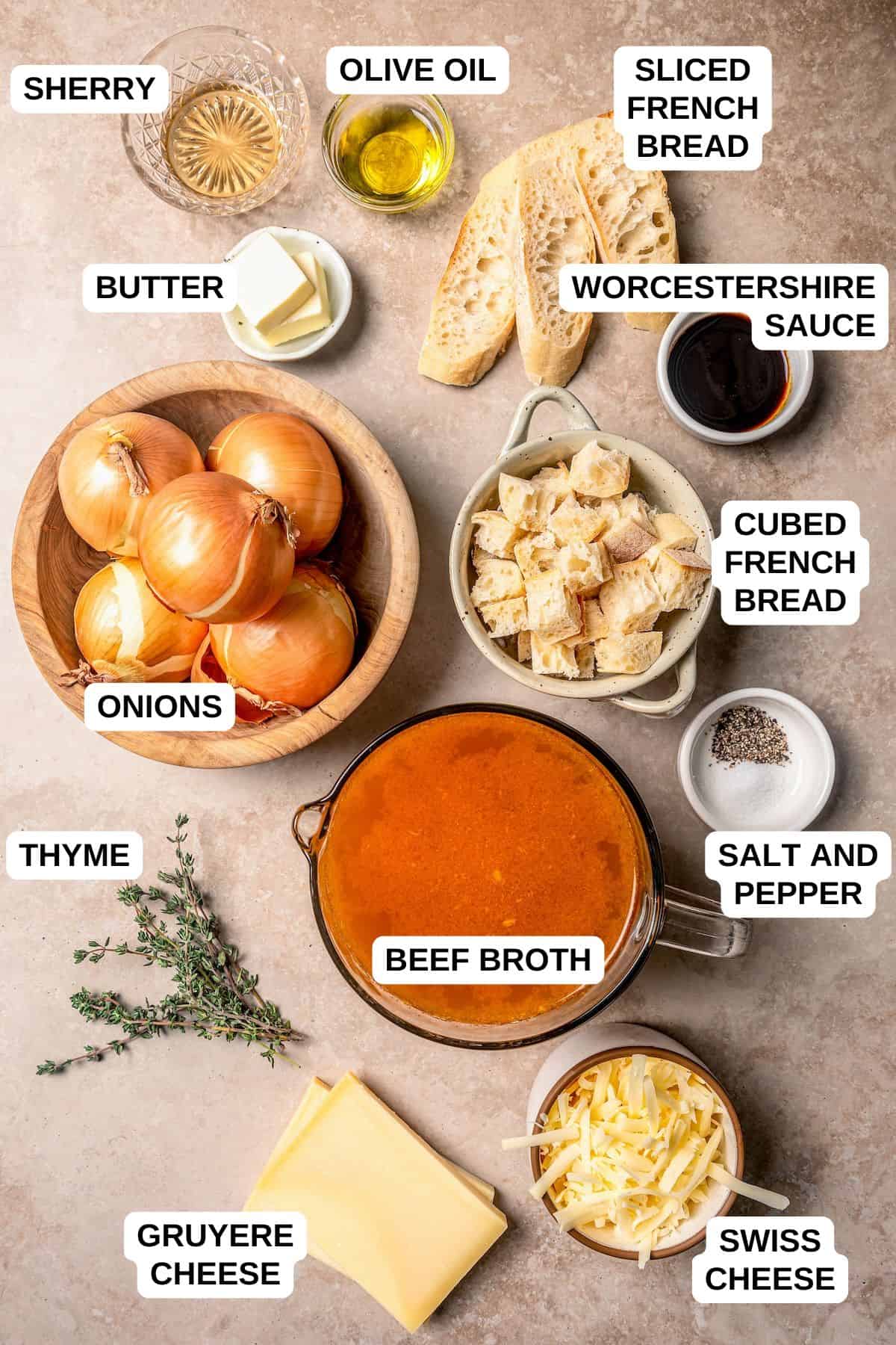 Ingredients laid out in separate bowls for making a French onion soup with swiss and Gruyere cheeses.
