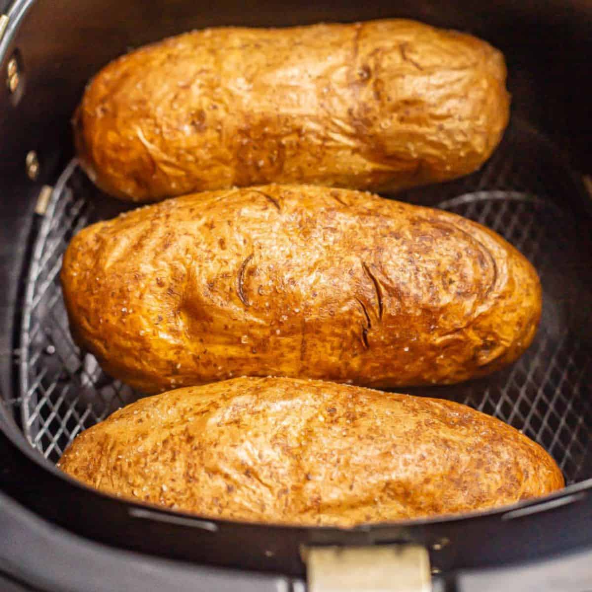 Close up of three russet potatoes being baked in the Air Fryer.