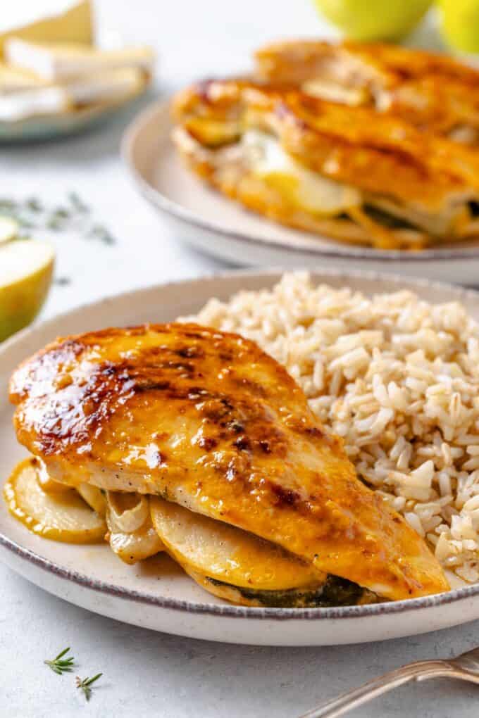 A stuffed chicken breast served on a white plate alongside steamed rice.