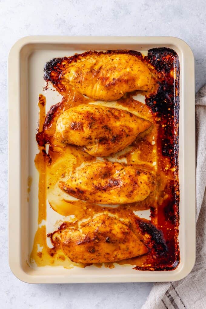 Roasted honey mustard chicken breasts on a sheet pan.