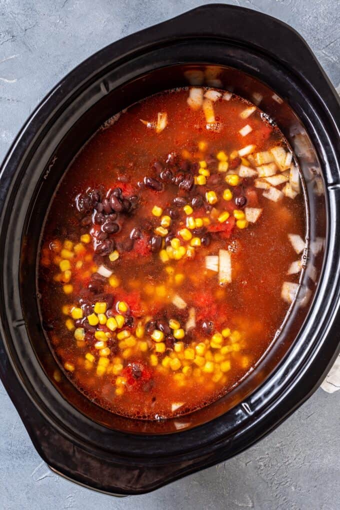 A slow cooker soup with black beans, tomatoes and corn.