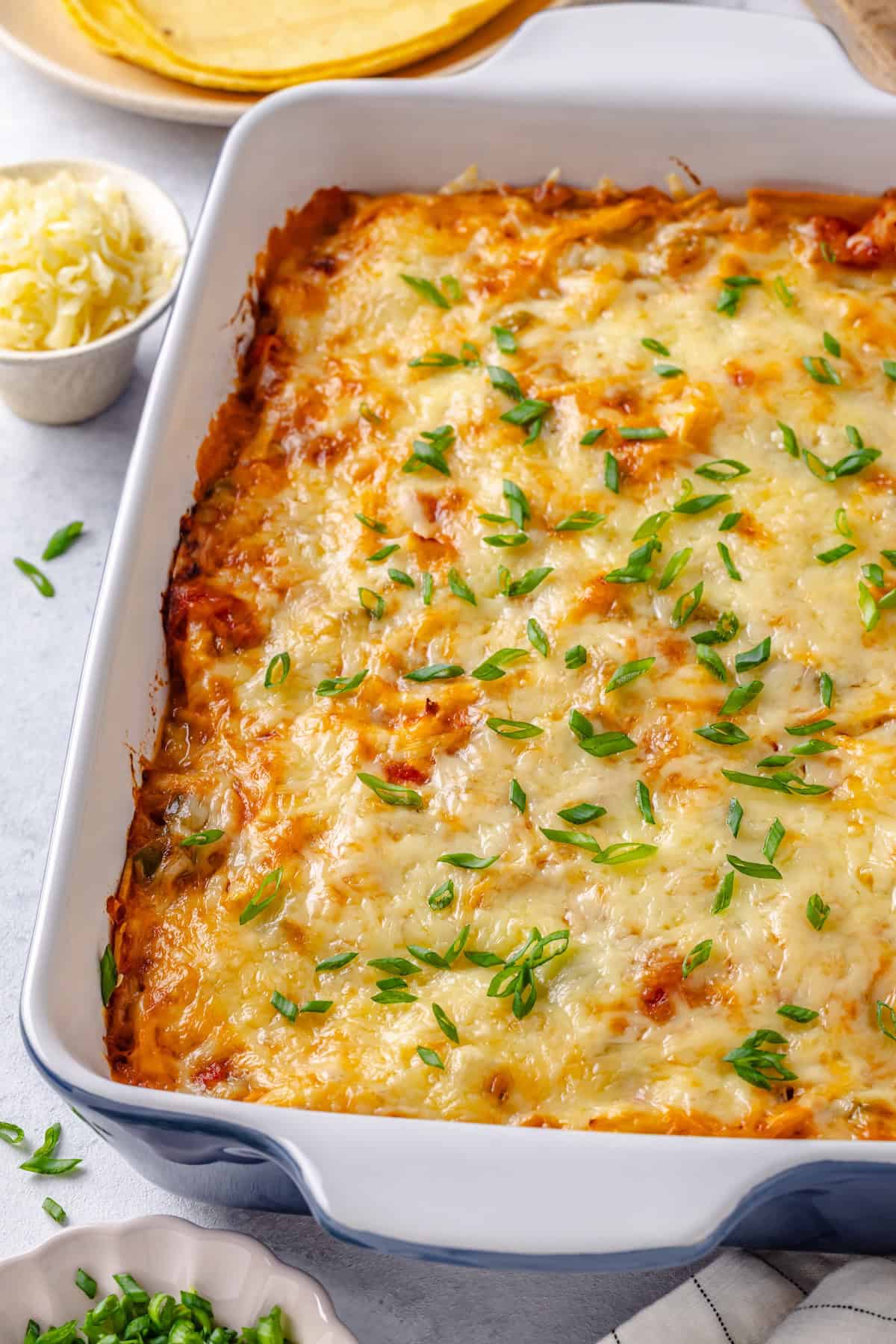 A baked cheesy chicken casserole in a blue and white rectangular dish.
