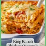 A spatula lifting up a square cut piece of a cheesy King Ranch chicken casserole from a blue and white baking dish with a text overlay on the photo and a green border around it.