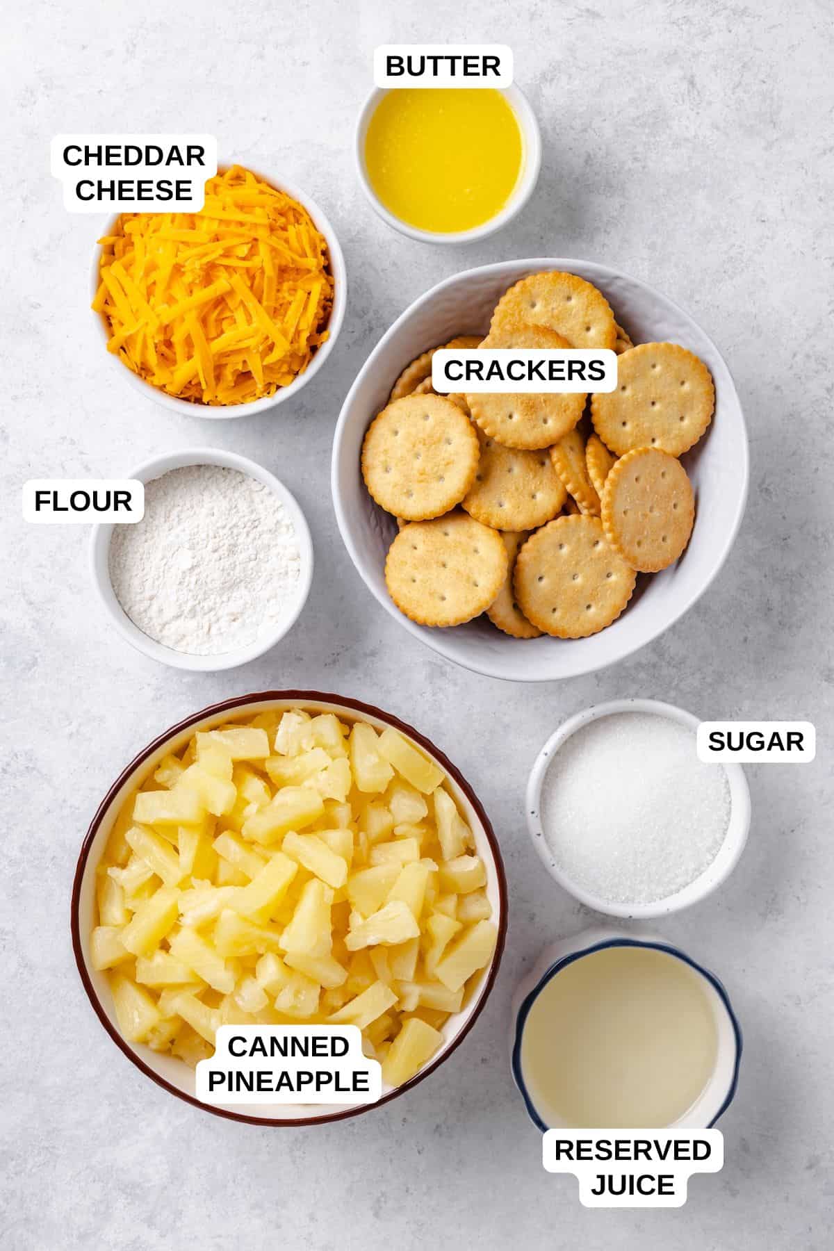Ingredients laid out in separate bowls for making a pineapple recipe with cheese and crackers.