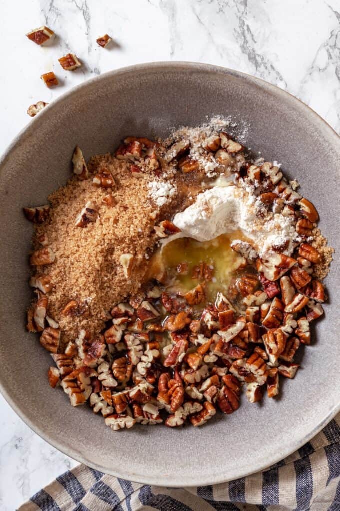 A bowl with a mixture of brown sugar, nuts, butter and flour.