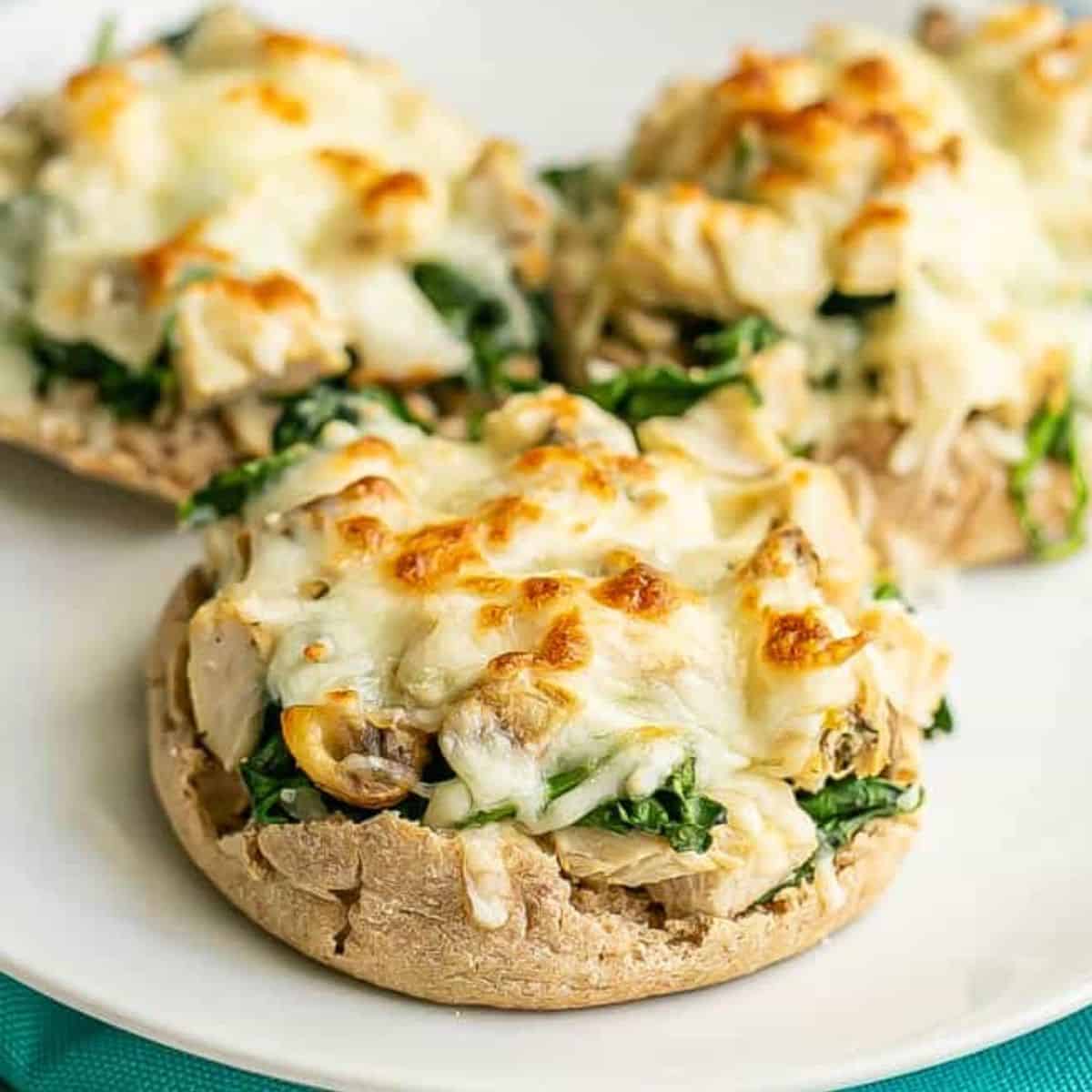 Close up of open faced turkey melts with spinach, mushrooms and mozzarella cheese.