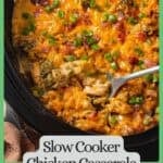A serving spoon scooping up some cheesy chicken casserole with potatoes and broccoli from a slow cooker insert with a green border and a text overlay on the photo.