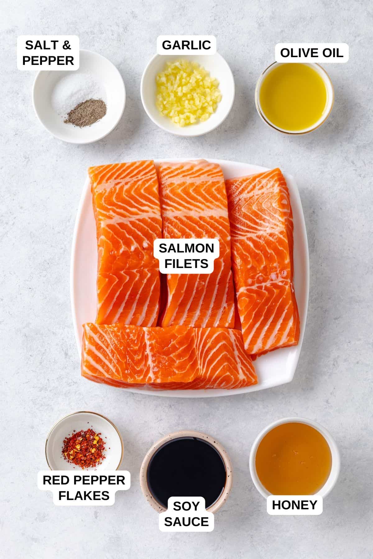 Ingredients laid out in different bowls for making a salmon recipe with a honey garlic sauce.