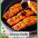 A spoon drizzling a honey garlic sauce over salmon filets in a dark skillet with a green border and text around the photo.
