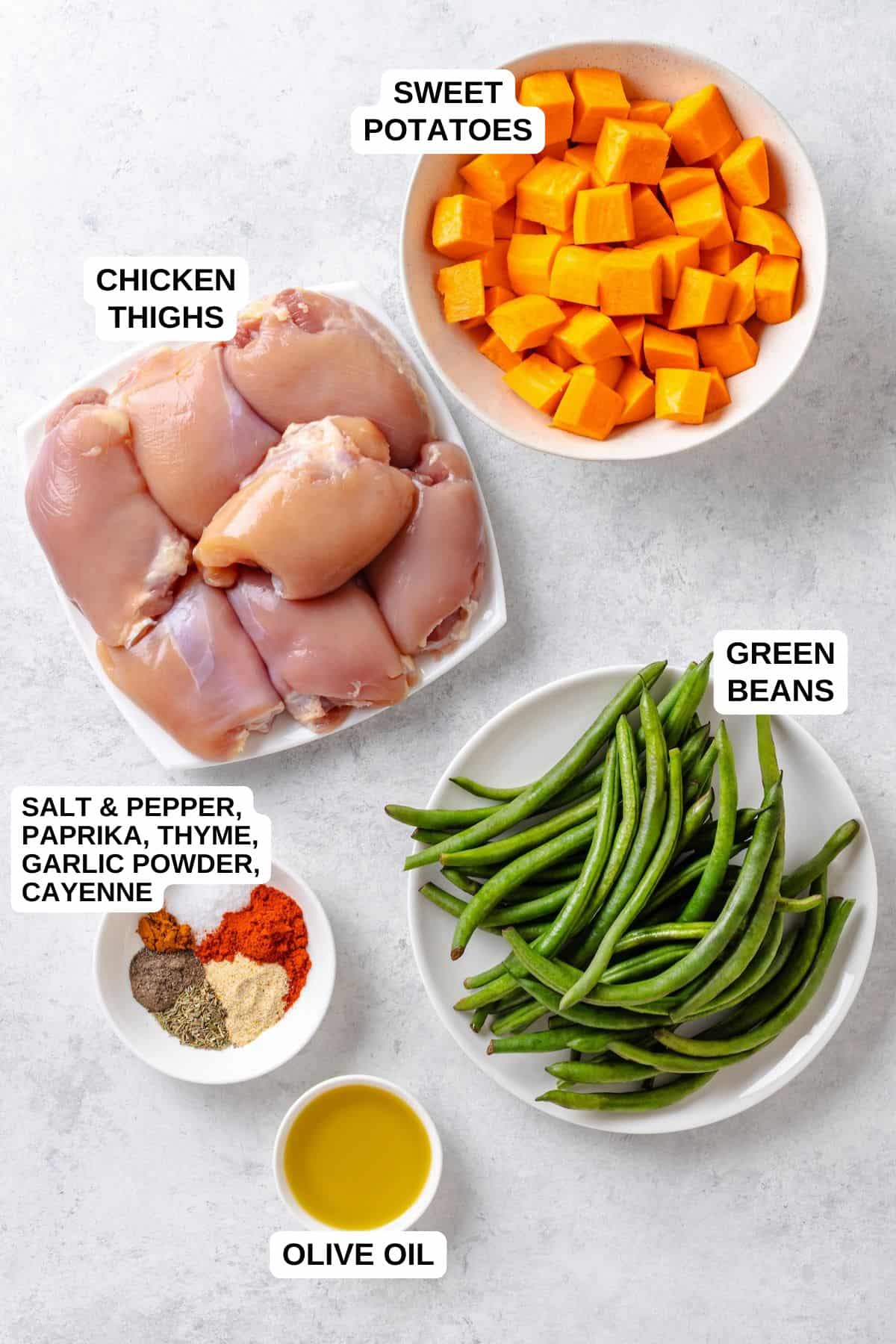 Ingredients laid out in separate bowls for making a chicken thighs recipe with sweet potatoes and green beans.