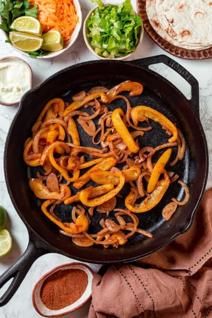 Sautéed onions and bell peppers in a cast iron skillet.