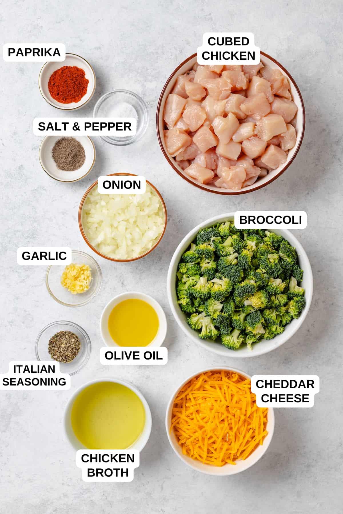 Ingredients laid out in separate bowls for making a cheesy chicken and broccoli recipe.