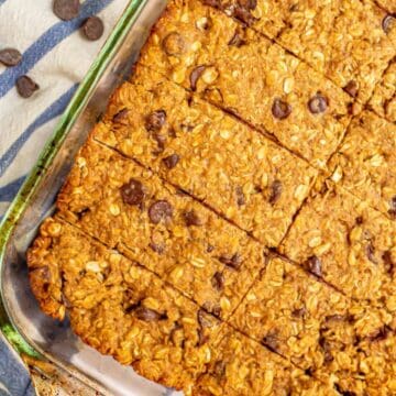 Close up of cut homemade granola bars with oats and chocolate chips in a glass 9x13 baking dish.