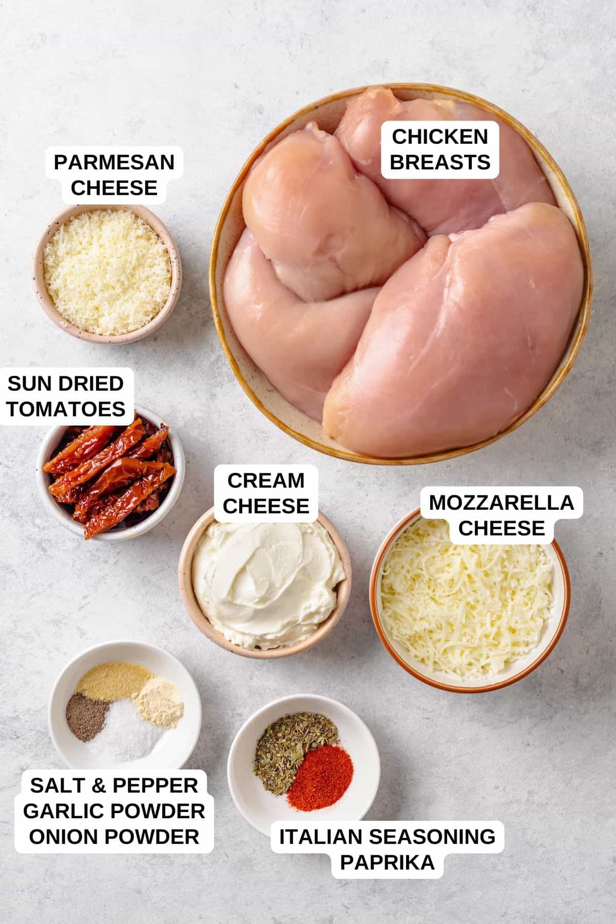 Ingredients laid out in separate containers for making a chicken recipe with cream cheese, mozzarella cheese and Parmesan cheese.
