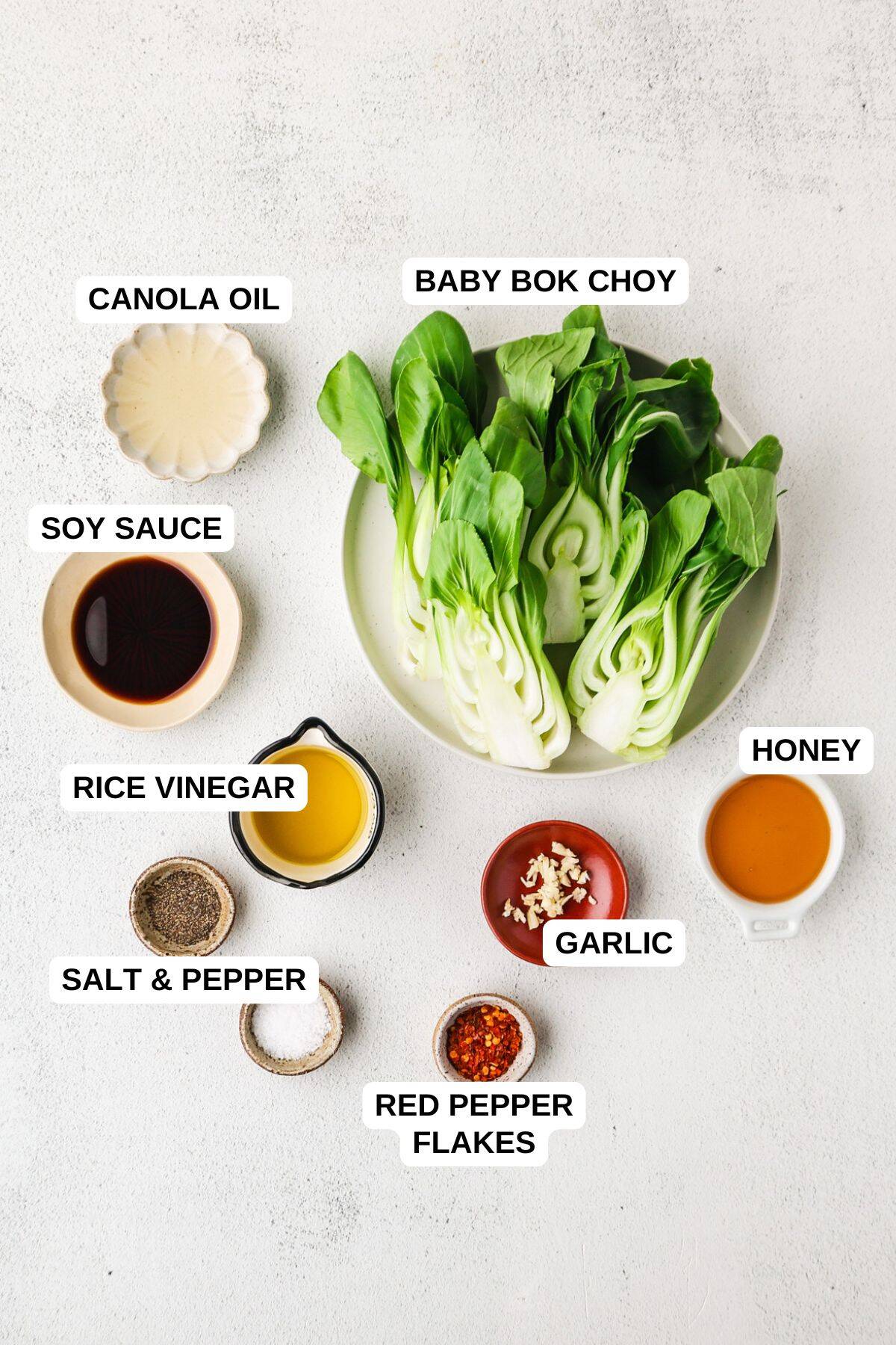 Ingredients laid out in separate bowls for making an Asian style baby bok choy recipe.