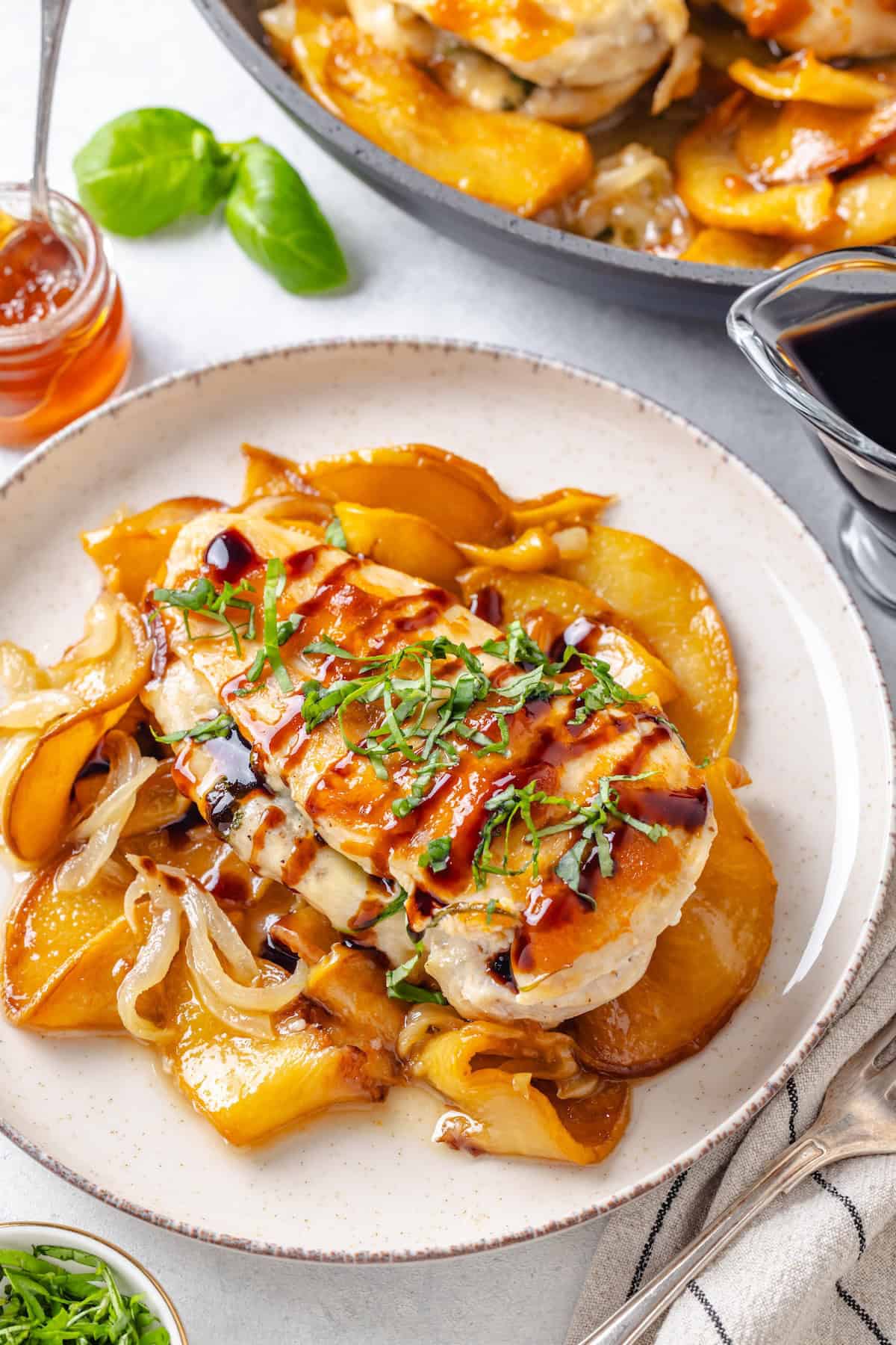 A brie cheese stuffed chicken breast with peach preserves, balsamic glaze and fresh basil on top served on top of sautéed onions and peaches.