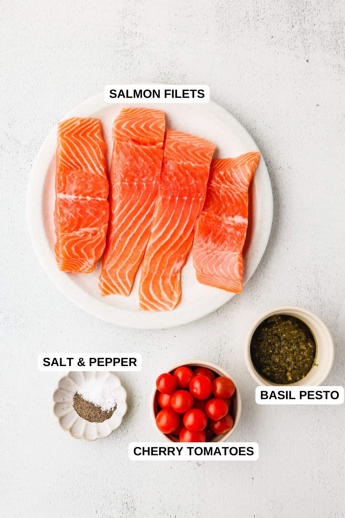Ingredients laid out in separate bowls and plates for making a salmon recipe with pesto.