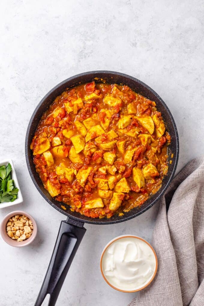 Rotisserie chicken in a homemade quick curry sauce in a skillet.