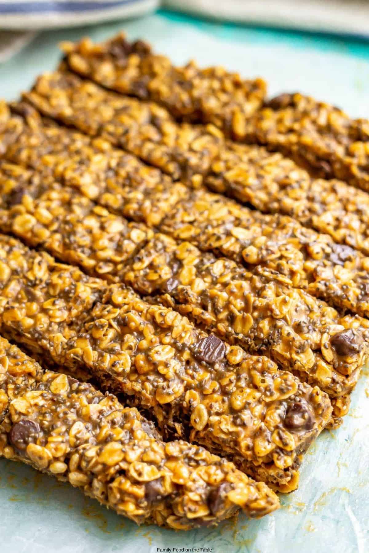 Sliced homemade no bake granola bars with chocolate chips on a piece of parchment paper.