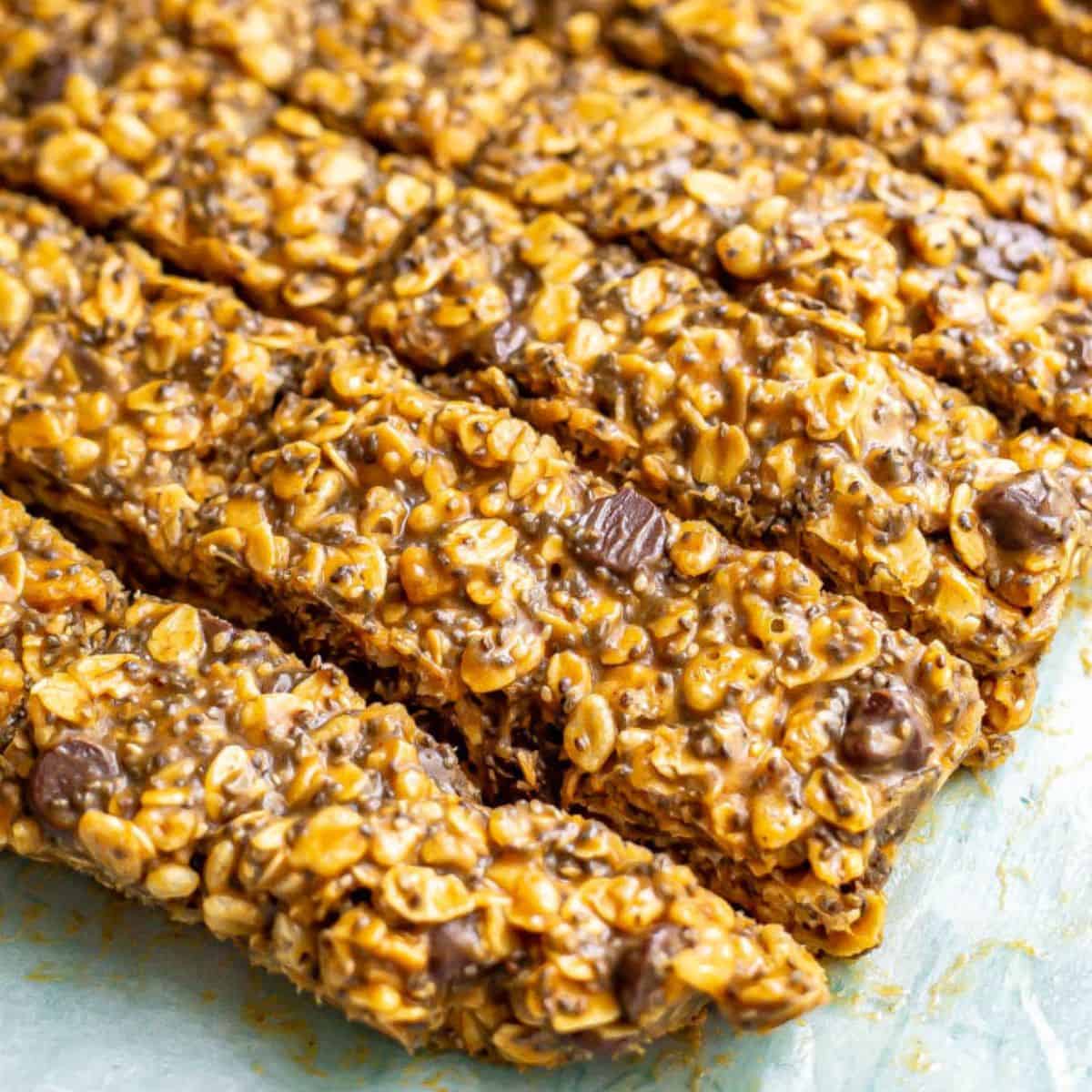 Close up of sliced homemade no bake granola bars with chocolate chips on a piece of parchment paper.