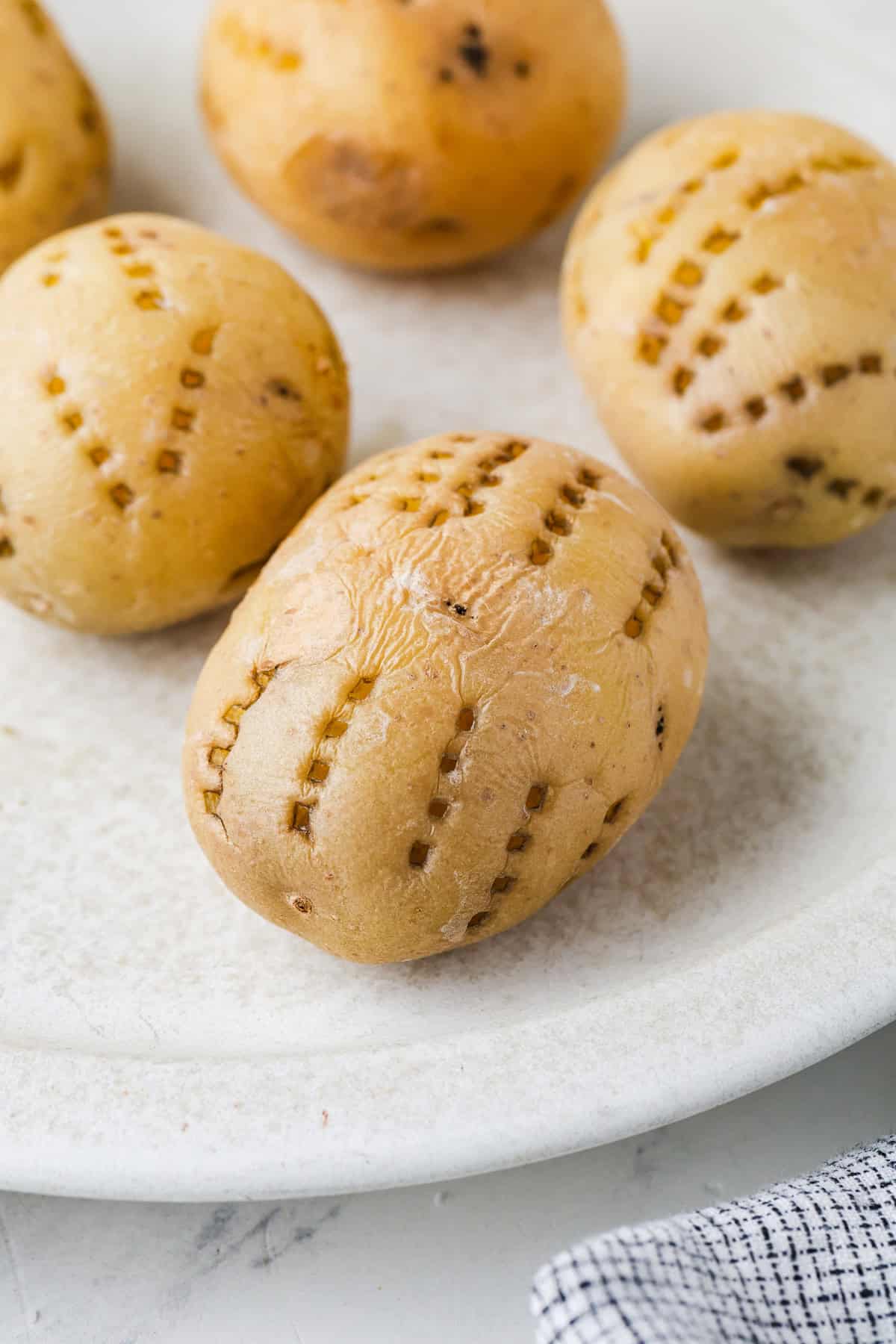 Close up of cooked Yukon potatoes with fork marks on them.